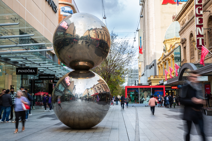 Landscape shot of Rundle Mall which focuses on the Malls Balls. Shoppers are also passing through when the photo was taken.