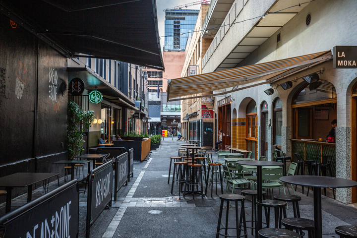 A shot Peel St in the Adelaide CBD, with multiple chairs and tables gathered together in the street.