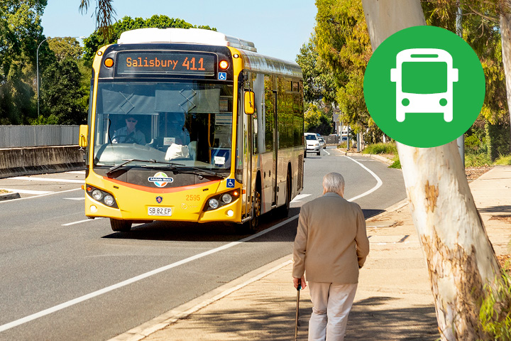 The 411 bus service travelling down a road. A elderly person is walking on the foot path and the Adelaide Metro green bus icon is pictured in the top right of the image.